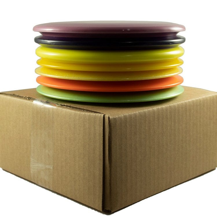 Stack of colorful disc golf discs on a cardboard box